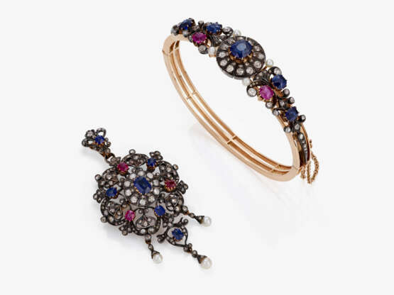 A demiparure consisting of a pendant/brooch and a bangle with very fine sapphires and rubies as well as diamonds and small pearls. Circa 1880 - фото 1