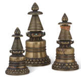 A GROUP OF THREE BRONZE KADAMPA STUPAS - фото 1