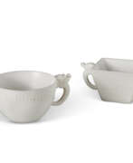 Cups. TWO CARVED WHITE STONE TWO-HANDLED CUPS