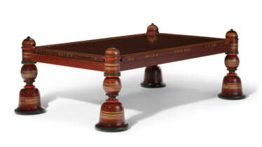 AN INDIAN STYLE RED AND POLYCHROME PAINTED COFFEE TABLE