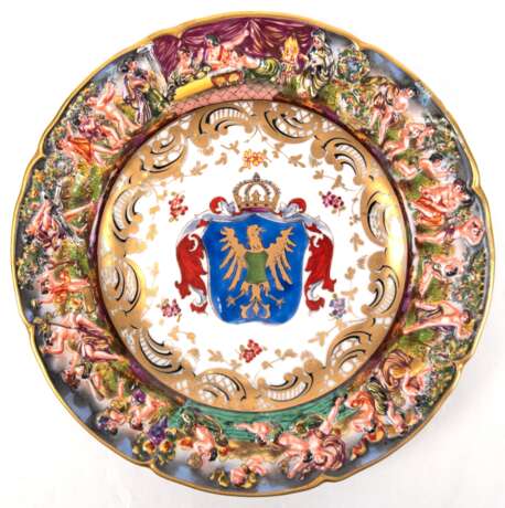 Teller, Wallendorfer Capodimonte, polychrom bemalt, Rand mit umlaufendem figürlichem Relief (bestoßen), im Spiegel bekröntes Wappen, Dm. 21,5 cm - photo 1