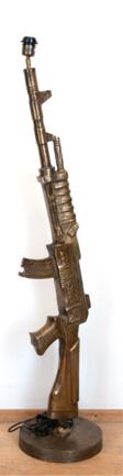 Lampenfuß in Form eines Maschinengewehres &amp;quot;Gunfireingsound Roma&amp;quot;, Metall, bronziert, 1-flammig, neu verkabelt, auf rundem Metallfuß,Ges.-H. 130 cm - Archives des enchères