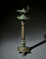 A LARGE AND IMPRESSIVE KHORASSAN BRONZE LAMPSTAND WITH OIL LAMP