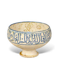A KASHAN MOULDED LUSTRE AND BLUE POTTERY BOWL