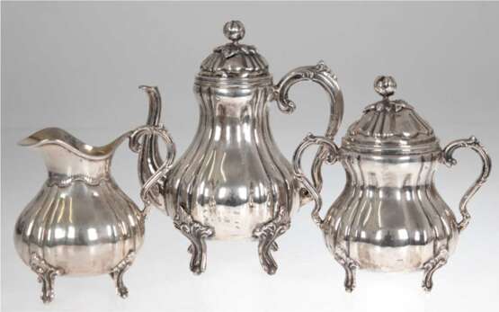 Kaffeekernstück, 3-teilig, 900er Silber innen vergoldet, je auf 4 Füßchen, vertikal gegliedert, Deckel mit plastischer Blütenknospe als Bekrönung, zus. 1685 g, Kannen-H. 22,5 cm - фото 1