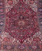 Teppiche & Textilien. Heriz, Retro, rotgrundig, blau/beige gemustert, Rand etwas verzogen, Fransen mit Fehlstellen, 352x251 cm