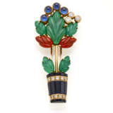 CARTIER | "Giardinetto" yellow gold brooch with sculpted green chalcedony and carnelian leaves, onyx vase and cabochon sapphire and diamond flowers, g 8.96 circa, length cm 4.40 circa. Signed Cartier, French assay and goldsmith marks, Italian hallma - Foto 1