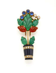CARTIER | "Giardinetto" yellow gold brooch with sculpted green chalcedony and carnelian leaves, onyx vase and cabochon sapphire and diamond flowers, g 8.96 circa, length cm 4.40 circa. Signed Cartier, French assay and goldsmith marks, Italian hallma