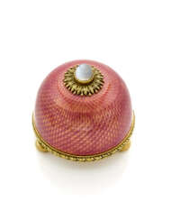 FABERGE' | Translucent opalescent pink guilloché enamel and yellow chiseled gold bell button accented with cabochon moonstone, gross g 73.00 circa, h cm 4.70, diam. cm 4.80 circa circa. Signed and marked Fabergé and KF in cyrillic, HW per Henrik Wigs