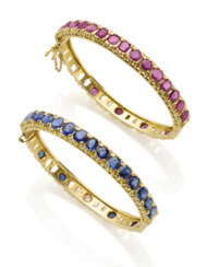 Pair of sapphire, ruby and yellow gold openable bangle bracelets, sapphires in all ct. 8.10 circa, rubies in all ct. 8.10 circa, in all g 49.79 circa, diam. cm 4.4 circa. (defects and losses)