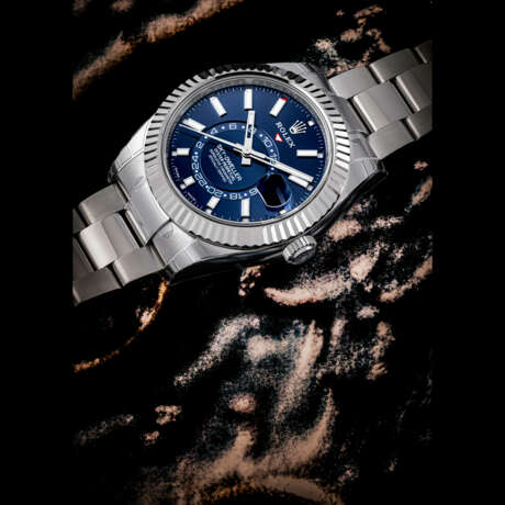 ROLEX. A STAINLESS STEEL AND WHITE GOLD ANNUAL CALENDAR AUTOMATIC WRISTWATCH WITH SWEEP CENTRE SECONDS, DUAL TIME, BRACELET AND BLUE DIAL - Foto 1