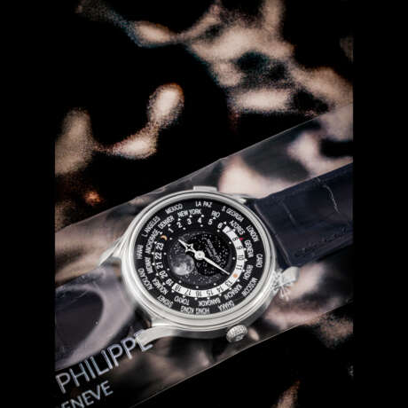 PATEK PHILIPPE. AN 18K WHITE GOLD LIMITED EDITION AUTOMATIC WORLD TIME WRISTWATCH WITH MOON PHASES, MADE TO COMMEMORATE THE 175TH ANNIVERSARY OF PATEK PHILIPPE, SINGLE SEALED - Foto 1