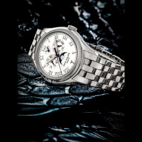 PATEK PHILIPPE. AN 18K WHITE GOLD AUTOMATIC ANNUAL CALENDAR WRISTWATCH WITH MOON PHASES, POWER RESERVE AND BRACELET - Foto 1