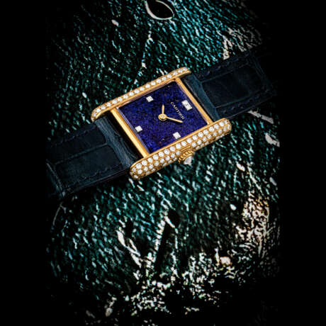 CARTIER. AN ATTRACTIVE 18K GOLD AND DIAMOND-SET WRISTWATCH WITH LAPIS LAZULI DIAL - Foto 1