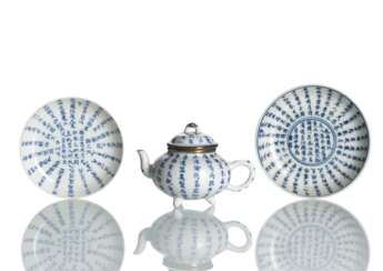 Zwei Schälchen und ein Teekännchen aus Porzellan mit Kalligraphie in Unterglasurblau