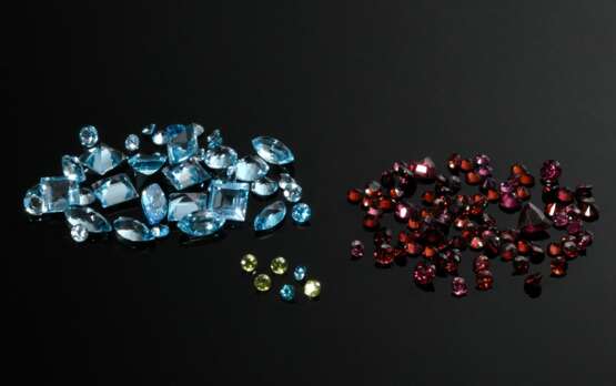 Konvolut diverser ungefasster Edelsteine: Peridots (zus. ca. 1.20ct), Zirkone (zus. ca. 0.75ct), Granate (zus. ca. 25ct) und blaue Topase (zus. ca. 90.75ct) in unterschiedlichen Schliffen und Formen - фото 1