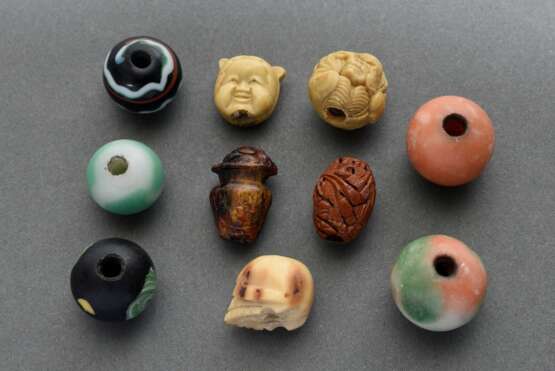 10 Diverse Ojime (緒締め) Perlen aus verschiedenen Materialien: 1 geschnitzter Obstkern (sign.), 1 Bein "Schädel", 1 Bernstein "Vase mit Karako", 2 Resin "Wendekopf: Okame oder Oni" und "G… - Foto 1