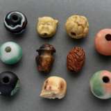 10 Diverse Ojime (緒締め) Perlen aus verschiedenen Materialien: 1 geschnitzter Obstkern (sign.), 1 Bein "Schädel", 1 Bernstein "Vase mit Karako", 2 Resin "Wendekopf: Okame oder Oni" und "G… - photo 1