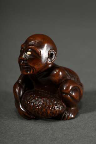 Buchsbaum Netsuke "Blinder Steinheber", Auge in Bein eingelegt, auf eingelegter Bein Kartusche, sign. Gyokkei (Davey 378), Mitte 19.Jh., verschieden große Himotoshi, schöne Patina, alter Sammlungskleber, H. 3,3… - photo 2