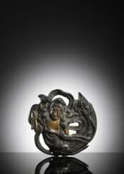Beschlag in Form eines Tennin aus Bronze, eine Lotusblüte haltend