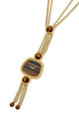 PIAGET. A HIGHLY RARE AND OPULENT 18K GOLD AND TIGER&#39;S EYE NECKLACE WATCH