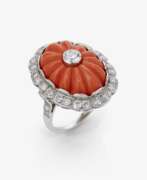 Hand jewellery. A historical ring decorated with a cut Midway coral and brilliant-cut diamonds