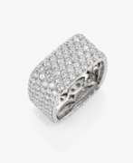 Hand jewellery. A modern band ring decorated with brilliant-cut diamonds