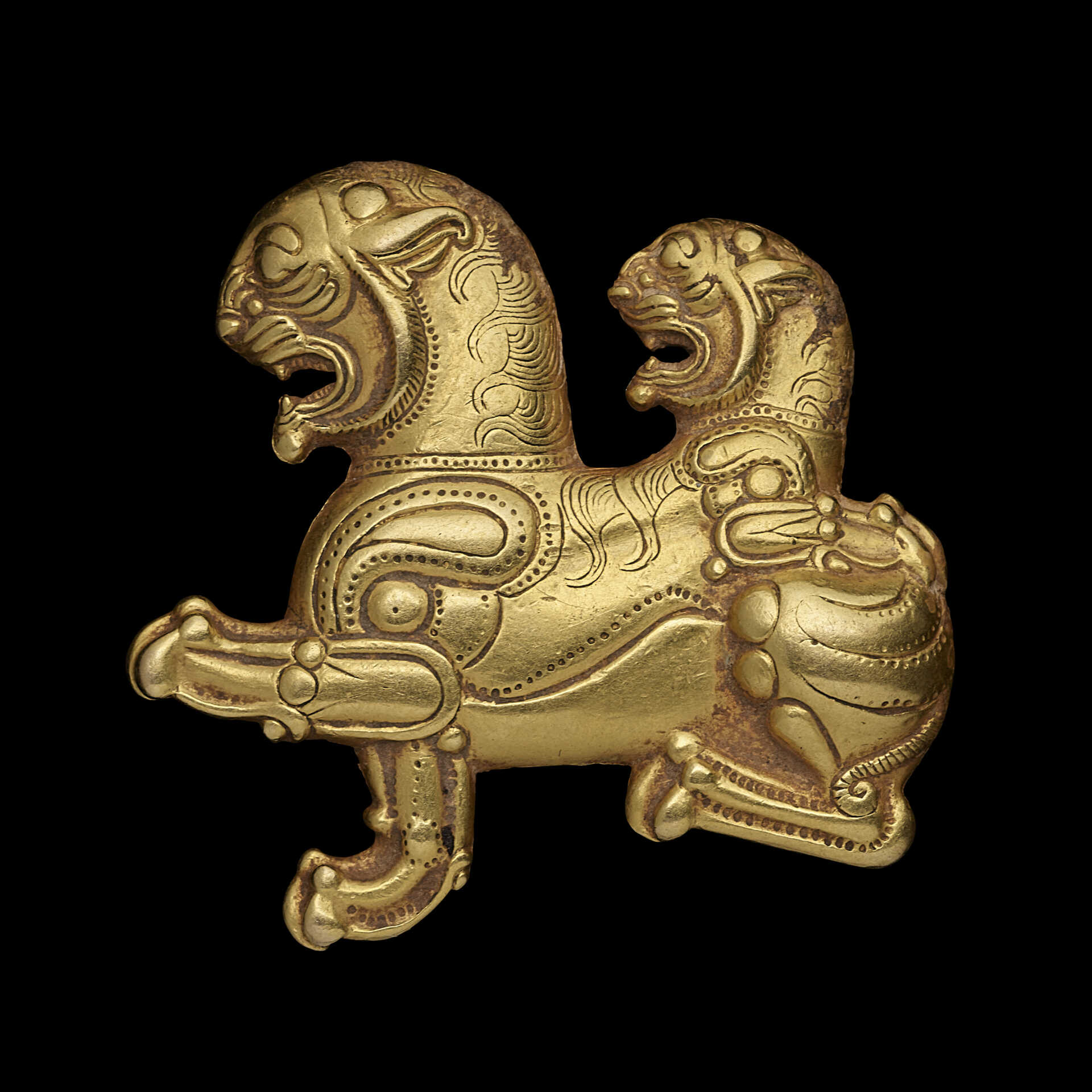 AN ACHAEMENID GOLD APPLIQUE OF A HYBRID LION