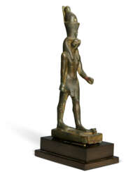 AN EGYPTIAN BRONZE HORUS STANDING ON AN IBEX