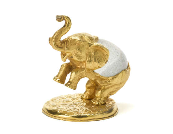 "Elefante" | Lost-wax sculpture of the series "Piccoli animali". 1970s. Hand-chiselled and gilded metal, Murano crystal glass egg by Barovier e Toso. Signed by incussion at the base. Metal label under the base. (10.5x14.5x12 cm.) | | Provenance | - photo 3