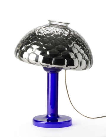 Table lamp model "Nina". Produced by Fontana Arte,, 1981. Transparent blue blown glass frame, adjustable silvered optical glass light diffuser. Bearing label. (h 50 cm.) | | Literature | G. Gramigna, Repertorio del design italiano 1950-2000 per l'a - фото 3