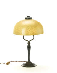 Table lamp. New York, 1920-28. Favrile' opaline and strongly iridescent yellow glass lampshade, patinated cast bronze stem. Inscribed "L. C. T. Favrile" on the upper rim of the of the shade, below the metal fastening ring. Engraved with the manufactu