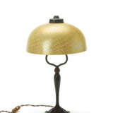 Table lamp. New York, 1920-28. Favrile' opaline and strongly iridescent yellow glass lampshade, patinated cast bronze stem. Inscribed "L. C. T. Favrile" on the upper rim of the of the shade, below the metal fastening ring. Engraved with the manufactu - Foto 3