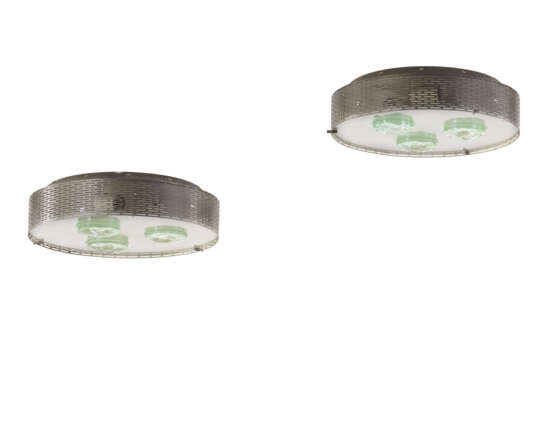 Pair of ceiling lamps model "2335". Milan, 1964ca. Perforated sheet metal frame, satin glass light diffuser with three chiselled crystal gem. (h 11 cm.; d 38 cm.) (slight defects) | | Provenance | Private collection, Milan | | Literature | Illum - Foto 1