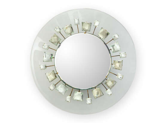 Wall mirror model "2044". Produced by Fontana Arte,, 1961. Coloured crystal frame, mirror attached to a brass sunburst with crystal gems. (d 74 cm.) (slight defects) | | Provenance | Private collection, Italy | | Literature | Arredamento, "Quade - photo 1