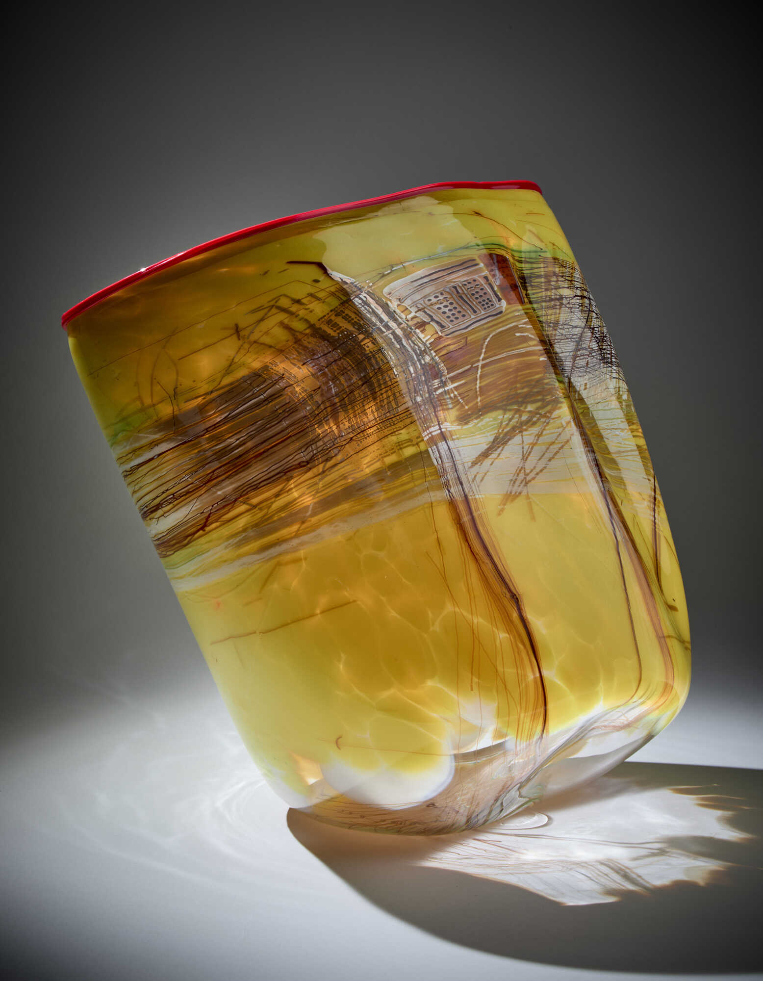 Large sculpture vase of irregular shape, attributable to the 'Soft Cylinders' series. Usa, 1996. Crystal and matt yellow blown glass with dark amethyst and lattimo glass filaments and murrine. Signed and dated with engraving under the base. (37.5x42.