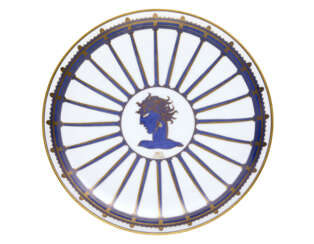 "Mea Lesbia" | Plate of the series "La passeggiata archeologica". Manufacture of Richard Ginori,, 1924. White porcelain chrome-decorated with gold and hand-painted in blue Ponti. Marked on the verso with the Pittoria di Doccia gold cartouche, "Richar