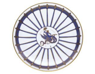 "La Perfida Cammilla" | Plate of the series "La passeggiata archeologica". Manufacture of Richard Ginori,, 1924. White porcelain chrome-decorated with gold and hand-painted in blue Ponti. Marked on the verso with the Pittoria di Doccia gold cartouche