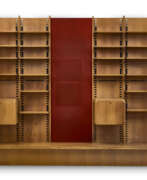 Libero Colma. Large custom-designed bookcase made of solid wood and veneer, consisting of three bays, the central one of which is set up with a backdrop covered in red fabric, two drop-down cabinets, twenty shelves, and a base. How, 1970s. (344x300x45 cm.) (slight