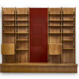 Large custom-designed bookcase made of solid wood and veneer, consisting of three bays, the central one of which is set up with a backdrop covered in red fabric, two drop-down cabinets, twenty shelves, and a base. How, 1970s. (344x300x45 cm.) (slight - фото 2