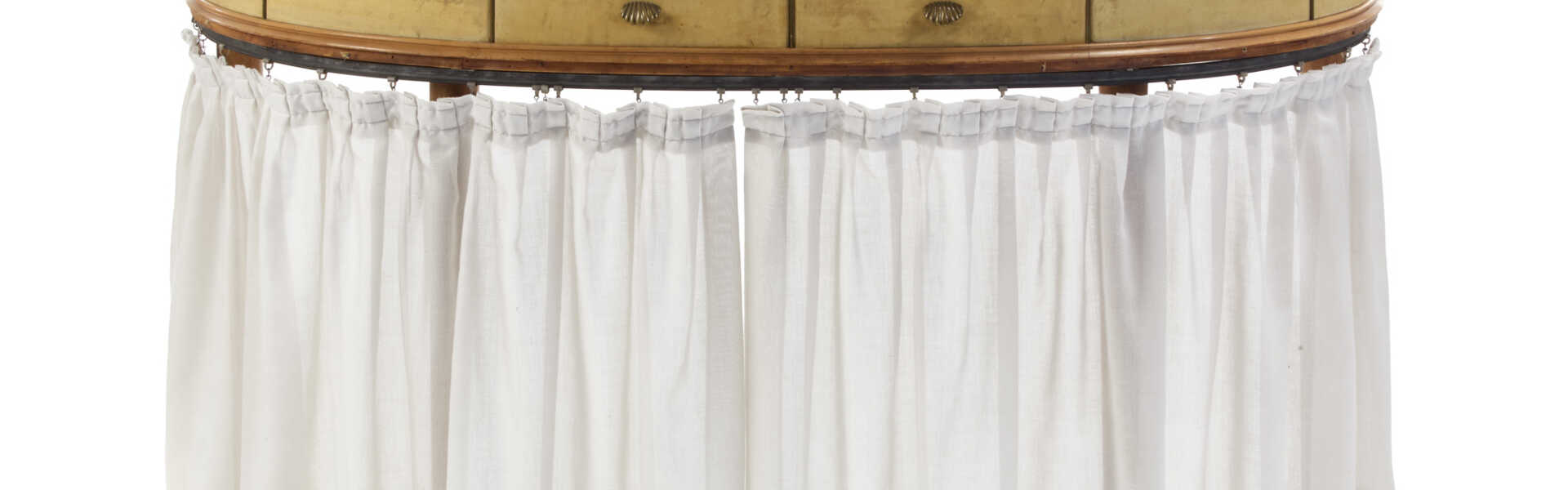 Two-drawers toilette. 1930s. Wooden frame, parchment upholstery, rose-coloured glass top, brass handles and finials. (137x73x43.5 cm.) (slight defects) | | Provenance | Private collection, Milan