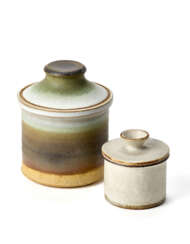 Two containers with lid. Execution by Ceramica Arcore,, 1970s. Ceramic enamelled in black-cream and brown and one in white. Marked "CA" under the base. (h max 12 cm.)