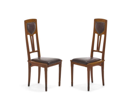 Pair of Liberty chairs. Milan, early 20th century. Solid wood carved, threaded and inlaid with different woods. Seat and back covered in brown leather. (41x100x42 cm.) (slight defects) - Foto 1