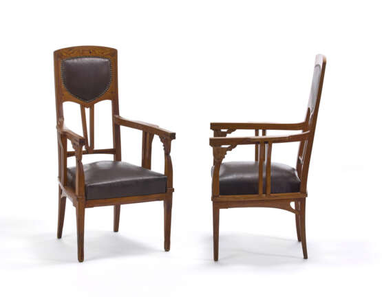 Pair of Liberty armchairs. Milan, early 20th century. Solid wood carved, threaded and inlaid with different woods. Seat and back covered in brown leather. (54x101x50 cm.) (slight defects) - Foto 1