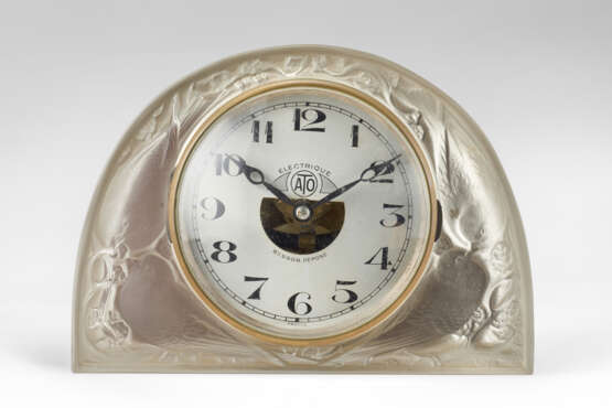 Electric table clock model "Moineaux". Execution by Lalique, France, 1924ca. Mould-pressed bevelled, satin,patinated and partially opalescent glass. (21.5x16x10 cm.) (slight defects) | | Literature | F. Marcilhac, René Lalique 1860-1945 maître-verr - Foto 1