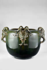 Large green enamelled ceramic cahepot under glaze, with satyr's head-shaped handles. Golfe Juan, France, early 20th century. Inscribed on the side: "CLEMENT MESSIER / GOLFE - JUAN (A. M.). (h 36.5 cm.; d 56 cm.) (slight defects)