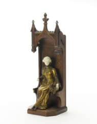 Chrysoelephantine sculpture depicting a woman seated with a book inside a neo-Gothic canopy throne. 1910s. Patinated bronze casting, ivory, carved wood. Signed A. Gorj on the side. Letters "HM" and number "800" engraved on the book. (h 53 cm.) (sligh