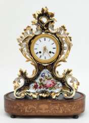 Porzellan-Tischuhr, um 1820, Pendel mit Fadenaufhängung, 1/2-Stundenschlag auf Glocke, gangfähig, ohne Schlüssel, reich verziertes Gehäuse mit floraler Malerei und reicher Goldstaffage, 35x26x10 cm, dazu angepaßter ovale…