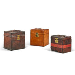 A GROUP OF THREE NATURAL LEATHER COWHIDE LEATHER HAT BOXES WITH BRASS HARDWARE