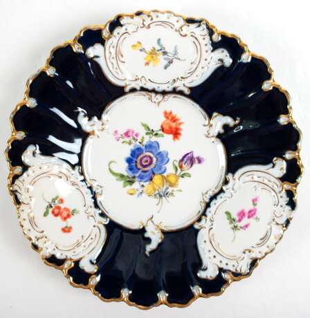 Meissen-Prunkteller, im Spiegel polychromes Blumenbukett, auf geschweift gerippter Fahne mit kobaltblauem Fond 3 goldgerahmte Medaillons mit Blumenmalerei, geschweifter Goldrand, 1. Wahl, Dm. 24 cm - Foto 1